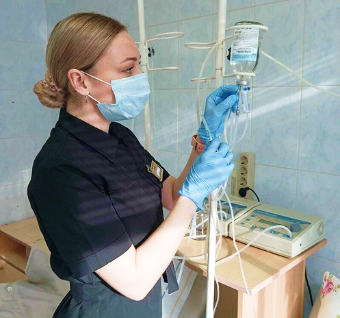 Медицинская сестра проводит процедуру капельницы